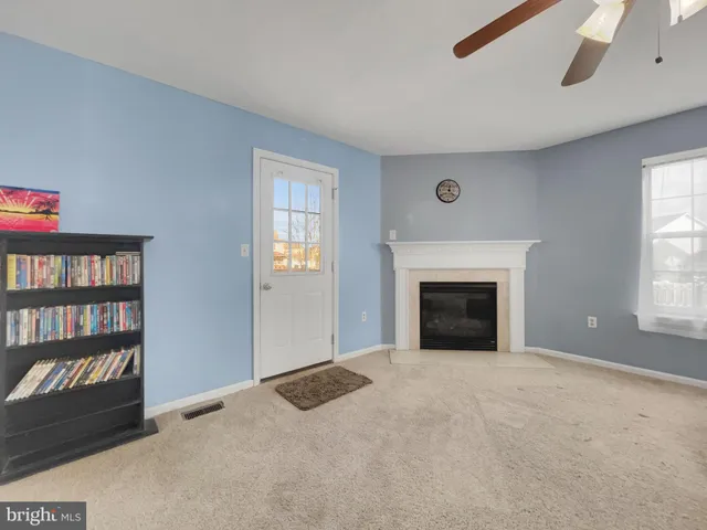a view of an empty room with a window and fireplace