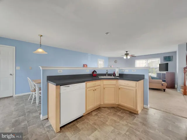 a kitchen with granite countertop a sink and white cabinets