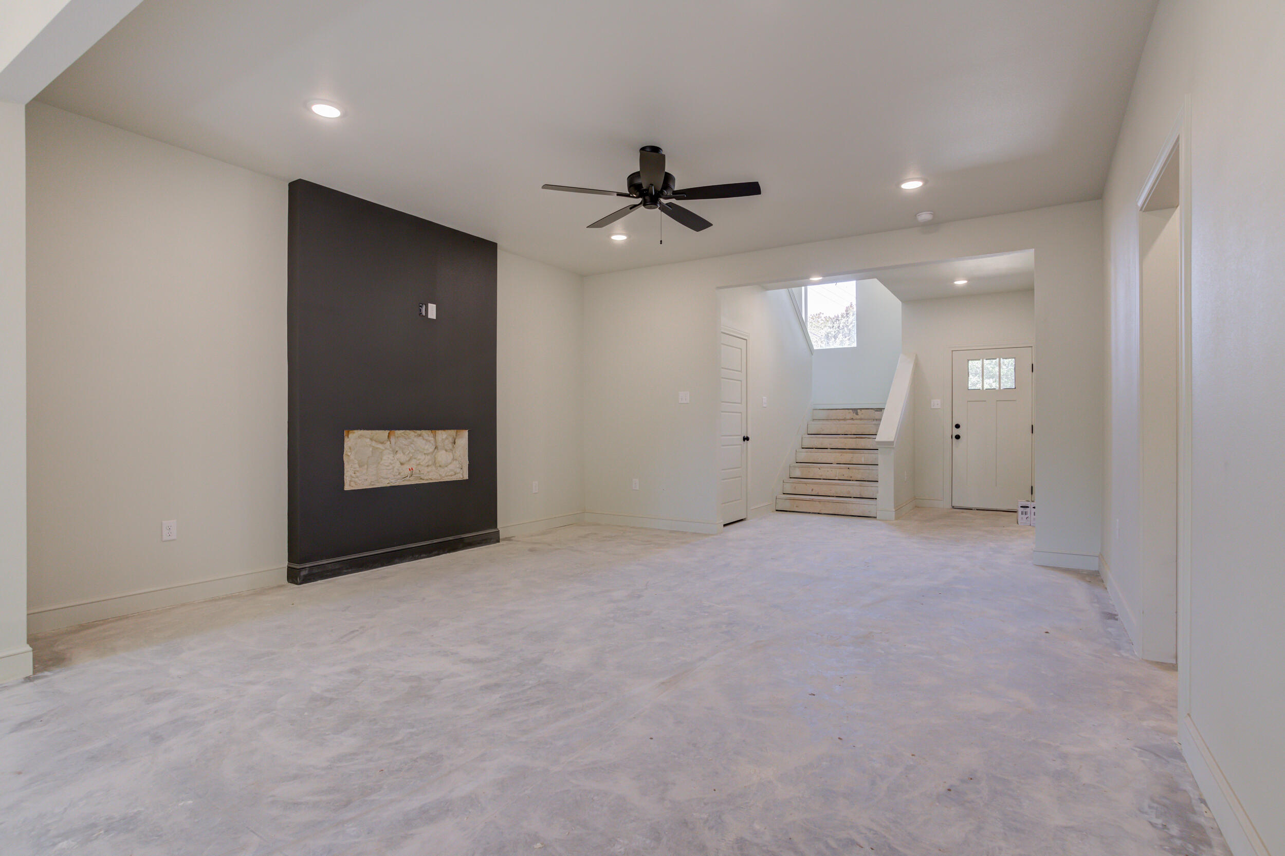 3423 24th Street Lubbock, TX 79410 - Photo 10 of 45 an empty room with a fireplace and a ceiling fan