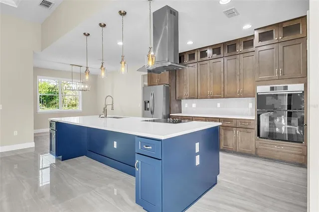 a kitchen with stainless steel appliances granite countertop a sink a stove and a wooden floors