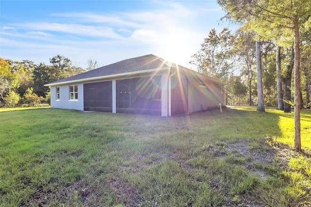 a view of a house with backyard and tree