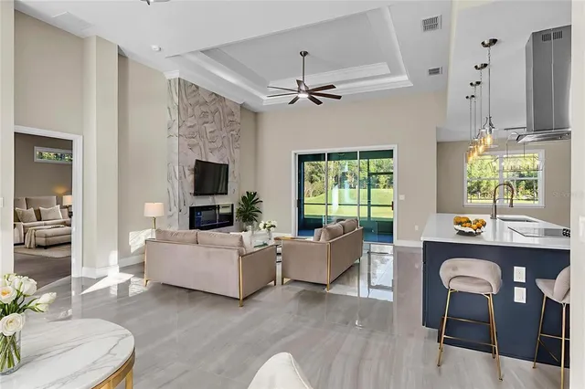 a living room with furniture a flat screen tv and a large window