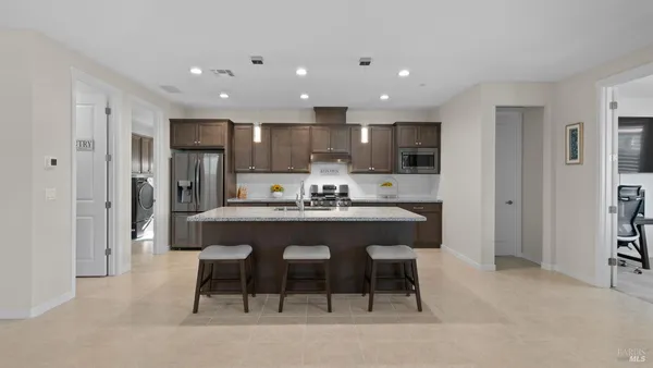 a utility room with lots of clutter and cabinets