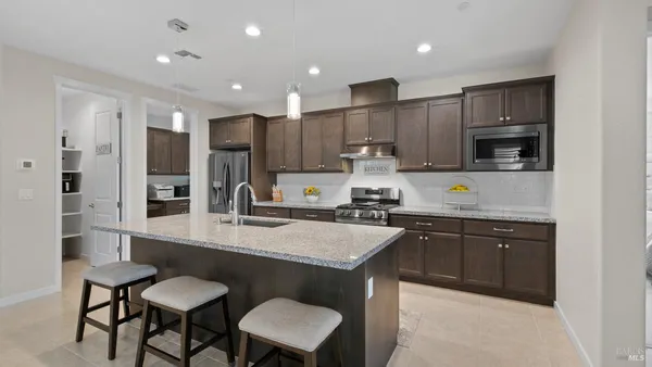 a kitchen with stainless steel appliances granite countertop a refrigerator and a stove