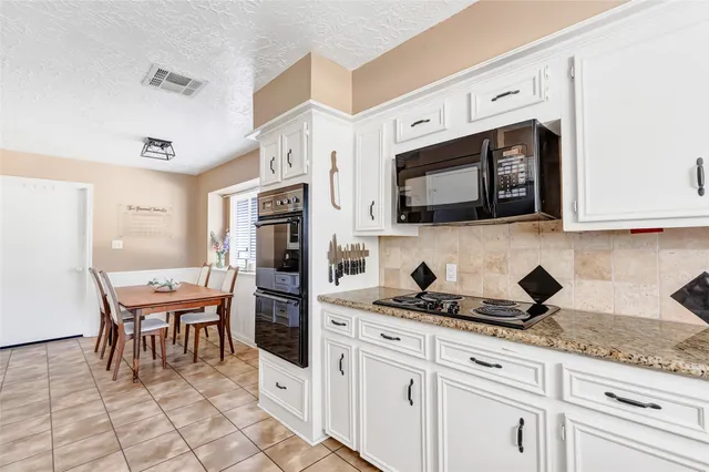 a kitchen with stainless steel appliances kitchen island granite countertop a stove a sink and a microwave