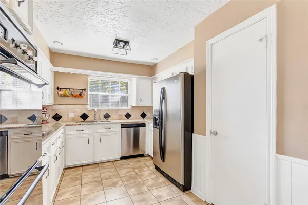 a kitchen with a sink a refrigerator and a stove top oven