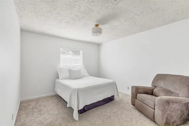 a bedroom with a bed couch and window