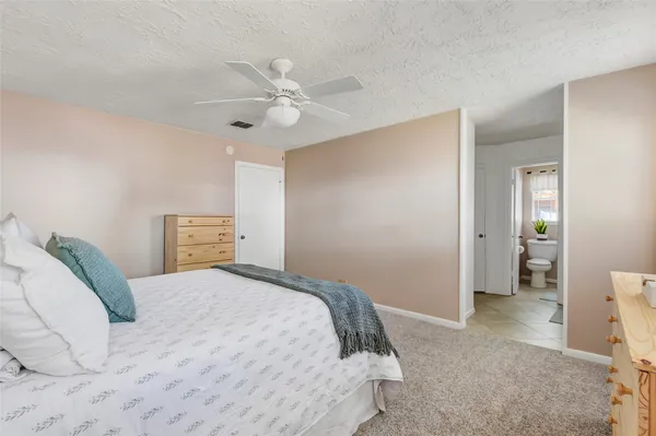 a bedroom with a large bed and a chandelier