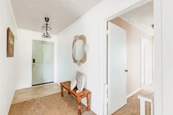a view of a hallway with entryway windows and wooden floors