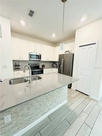 a kitchen with stainless steel appliances granite countertop a refrigerator a stove and a sink with granite countertops