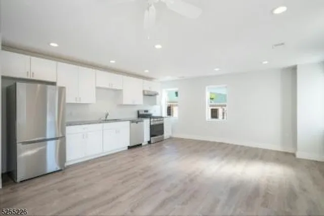 a kitchen with a refrigerator and white cabinets