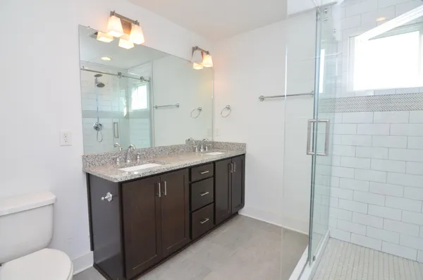 a bathroom with a granite countertop sink toilet and shower