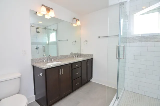 a bathroom with a granite countertop sink toilet and shower