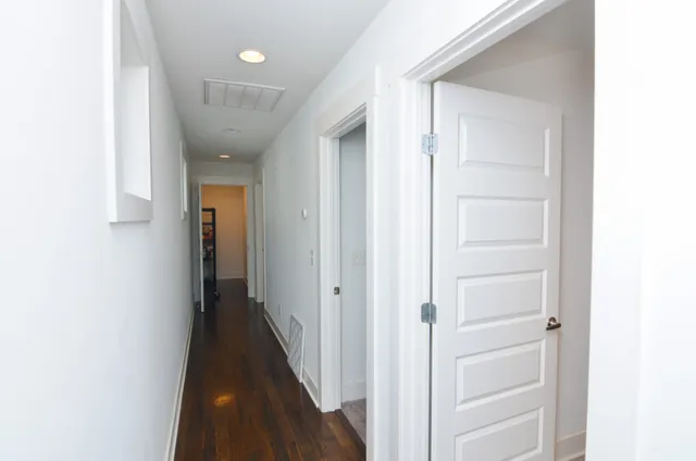 a view of a hallway with wooden floor