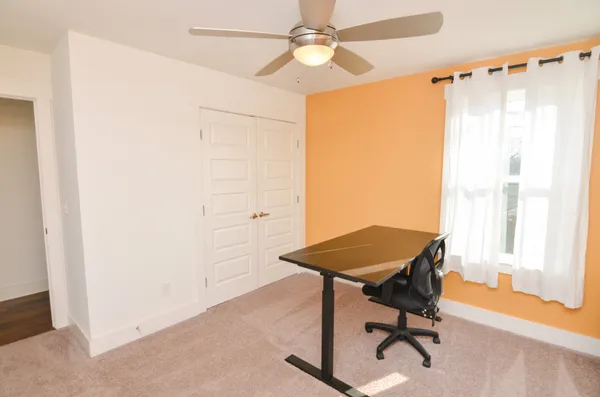 a view of a workspace with furniture and a window