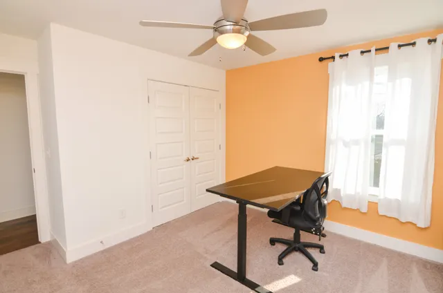 a view of a workspace with furniture and a window