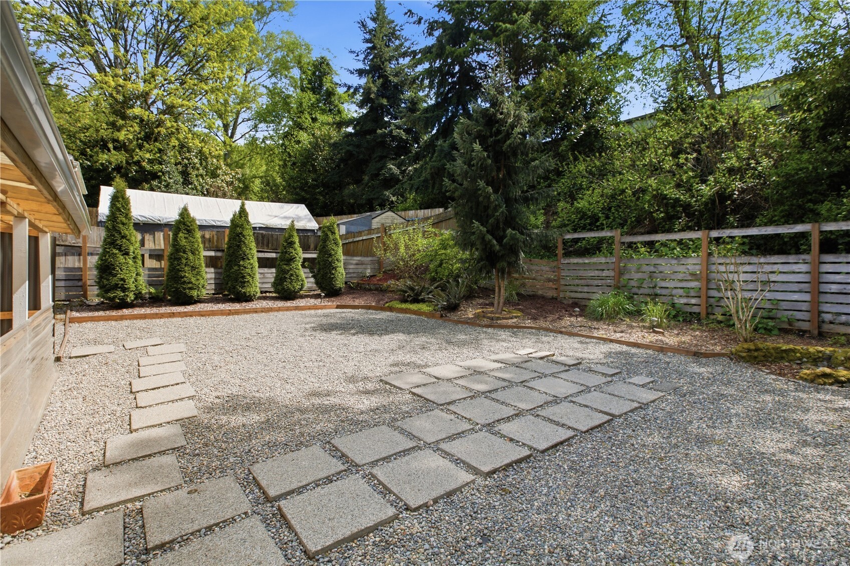 2307 Southwest Myrtle Street Seattle, WA 98106 - Photo 27 of 30 a view of backyard with large trees and a wooden fence