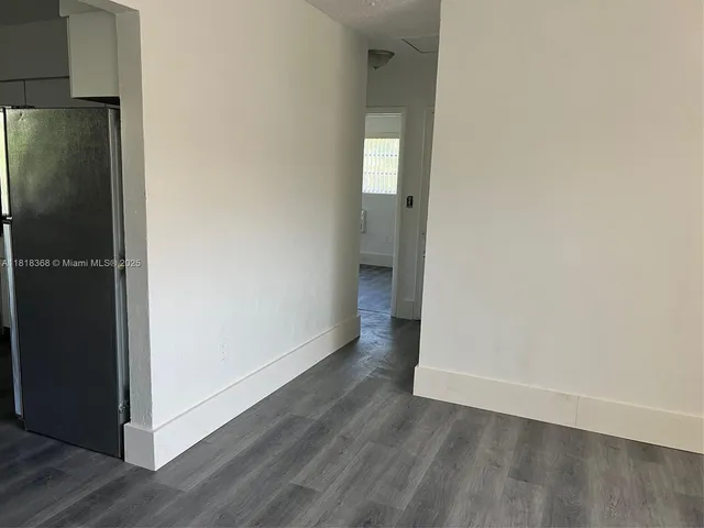 an empty room with wooden floor sink and closet