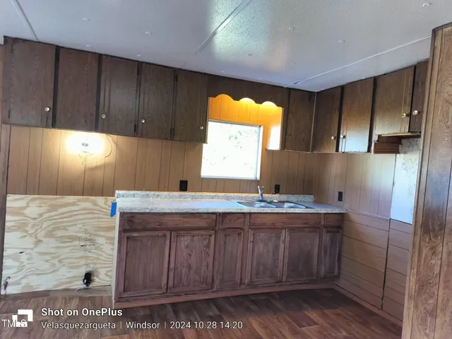 a kitchen with a sink cabinets and wooden floor