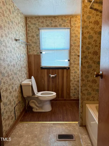 a bathroom with a toilet a sink and a mirror