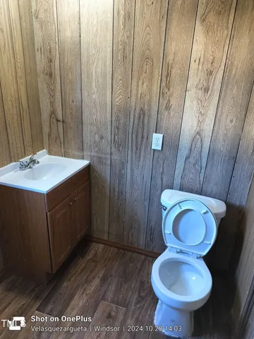a bathroom with a granite countertop toilet and a sink