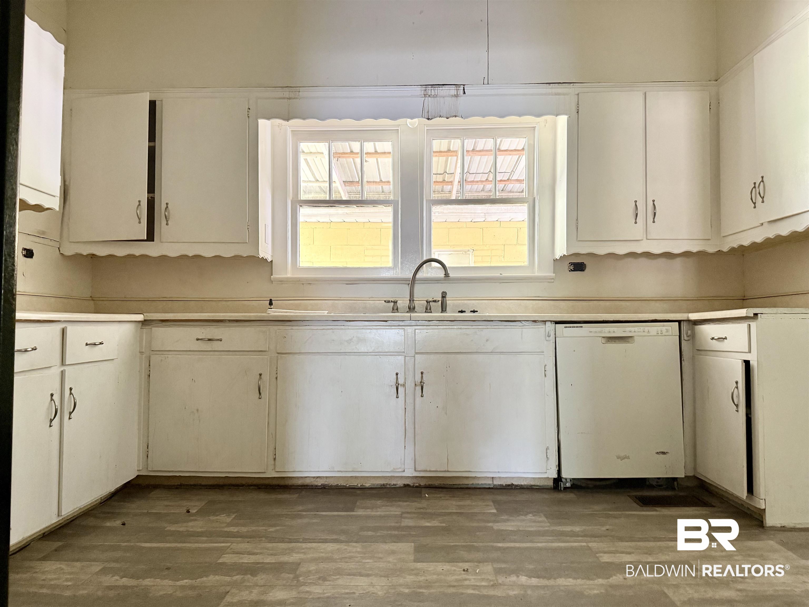 610 Alco Drive Brewton, AL 36426 - Photo 13 of 18 Kitchen featuring white dishwasher, light wood finished floors, light countertops, and white cabinets