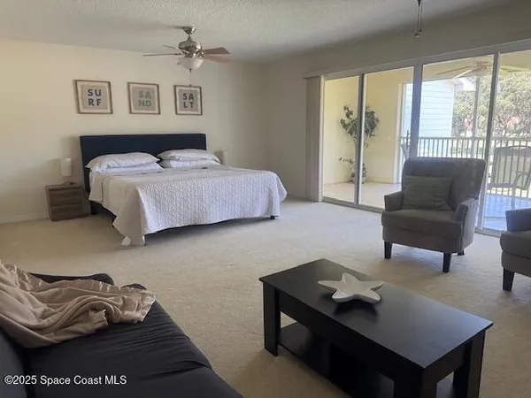 a bedroom with furniture and a large window