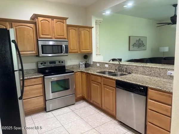 a kitchen with granite countertop a sink stove and microwave