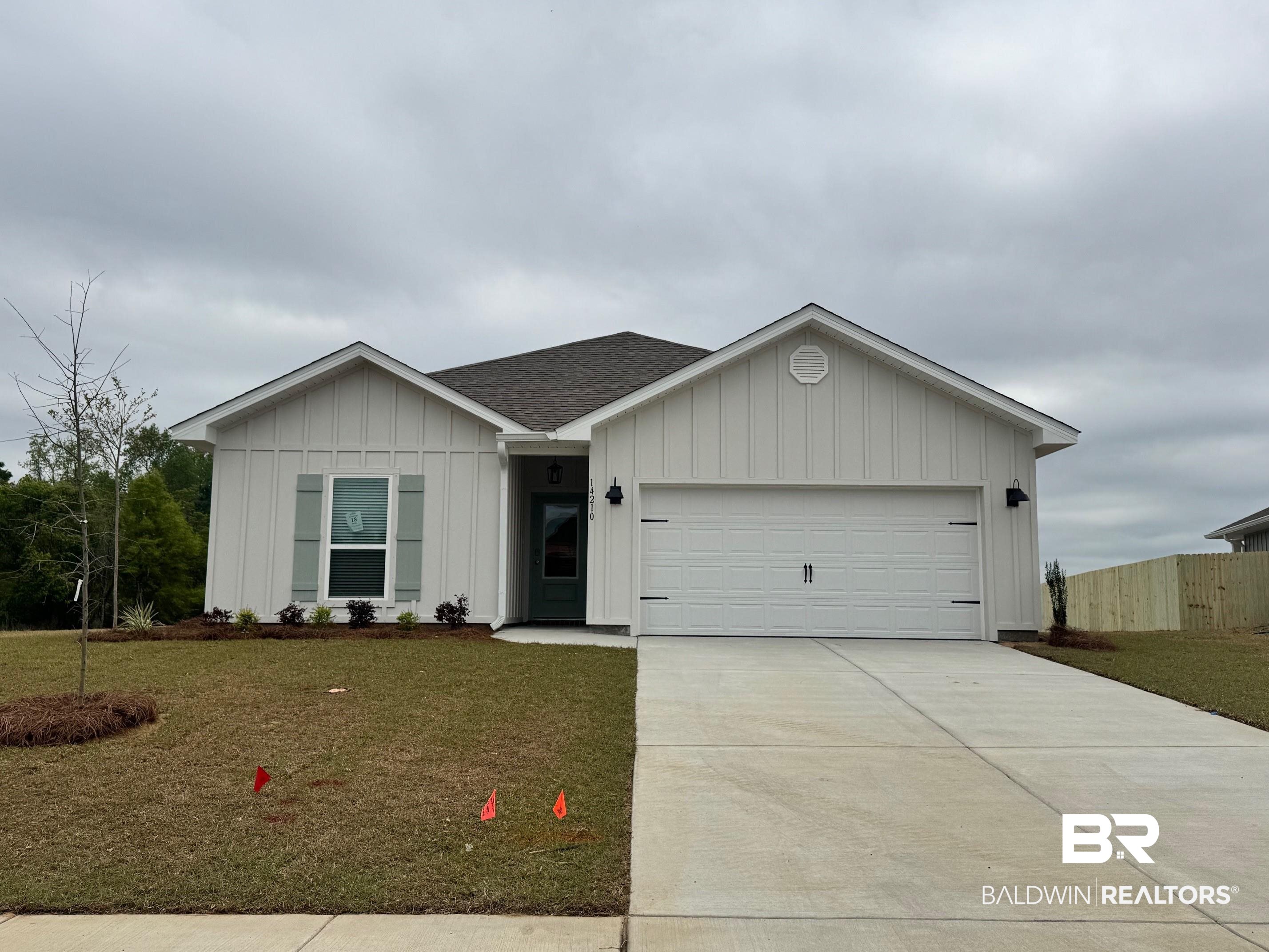 14210 Versailles Circle Silverhill, AL 36576 - Photo 1 of 36 Ranch-style house featuring board and batten siding, an attached garage, concrete driveway, and roof with shingles