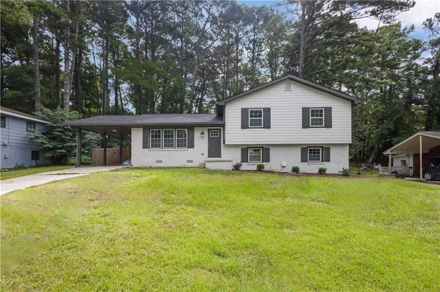 a view of a house with a yard and sitting area