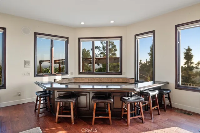 an empty room with wooden floor fireplace and windows