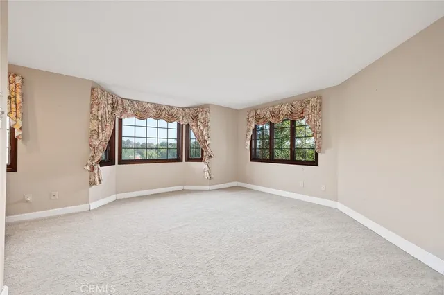 a view of an empty room with a fireplace and a window