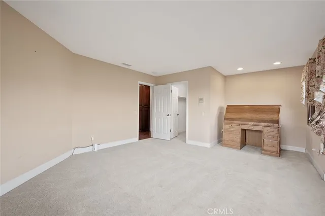 a view of an empty room with a fireplace and a rug