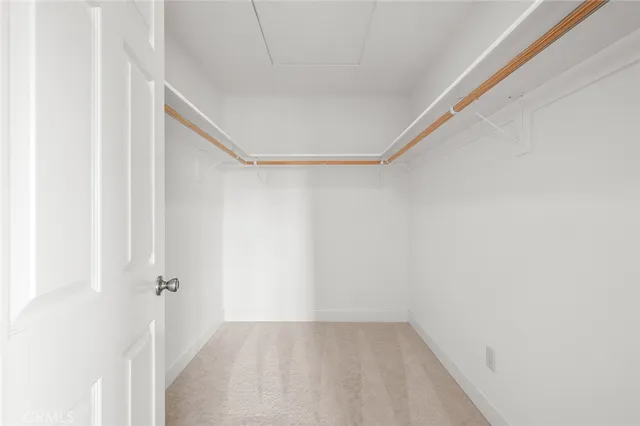 a view of an empty room with window and hardwood
