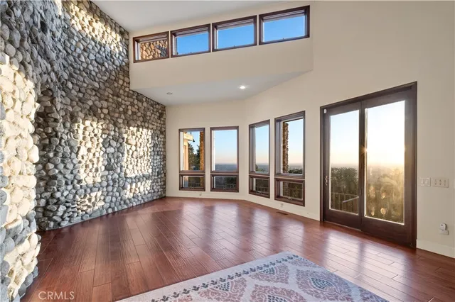 a view of a hallway with wooden floor and a chandelier