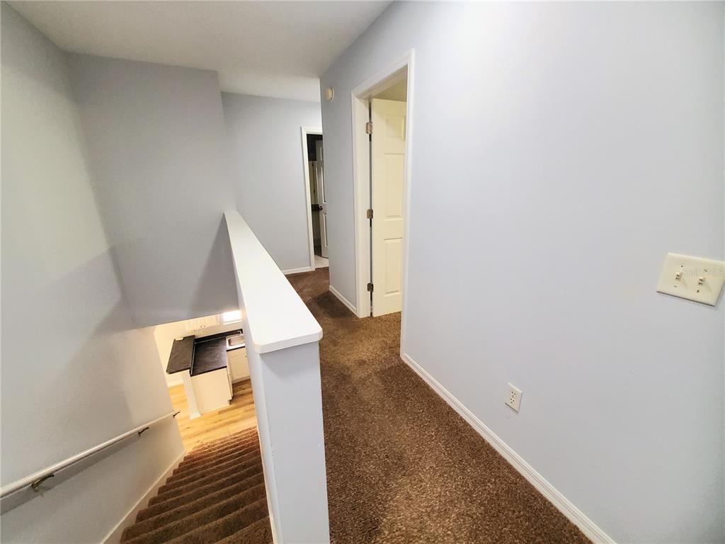 75 Atlantic Oaks Circle, Unit B St. Augustine, FL 32080 - Photo 16 of 25 a view of a hallway with wooden floor and staircase