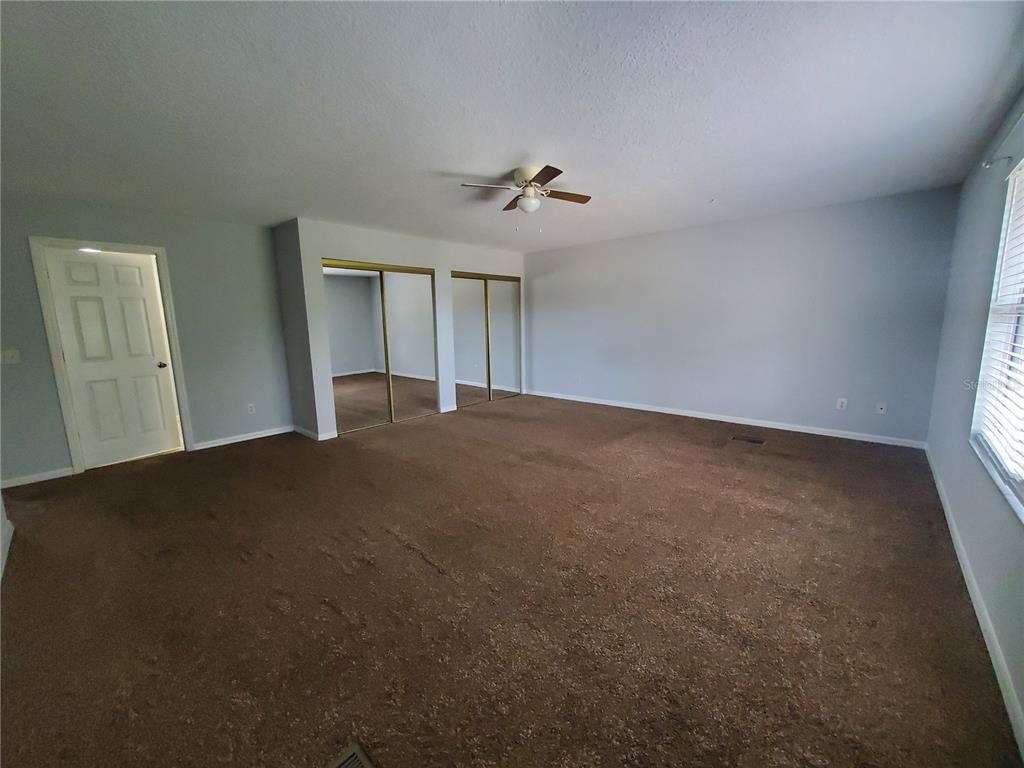 75 Atlantic Oaks Circle, Unit B St. Augustine, FL 32080 - Photo 17 of 25 an empty room with windows and fan