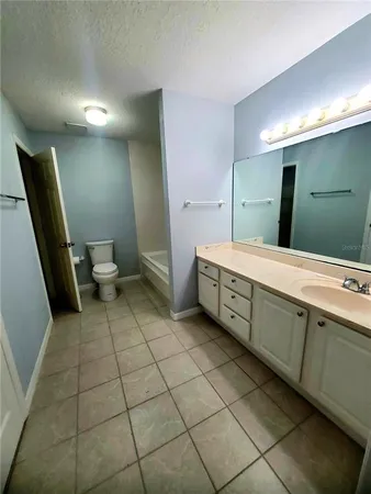 a spacious bathroom with a double vanity sink toilet and a mirror