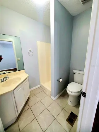 a bathroom with a granite countertop toilet and a sink