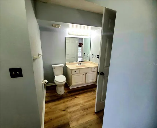 a bathroom with a sink mirror toilet and next to a window