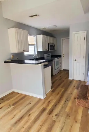 a kitchen with stainless steel appliances granite countertop a stove a sink and a refrigerator