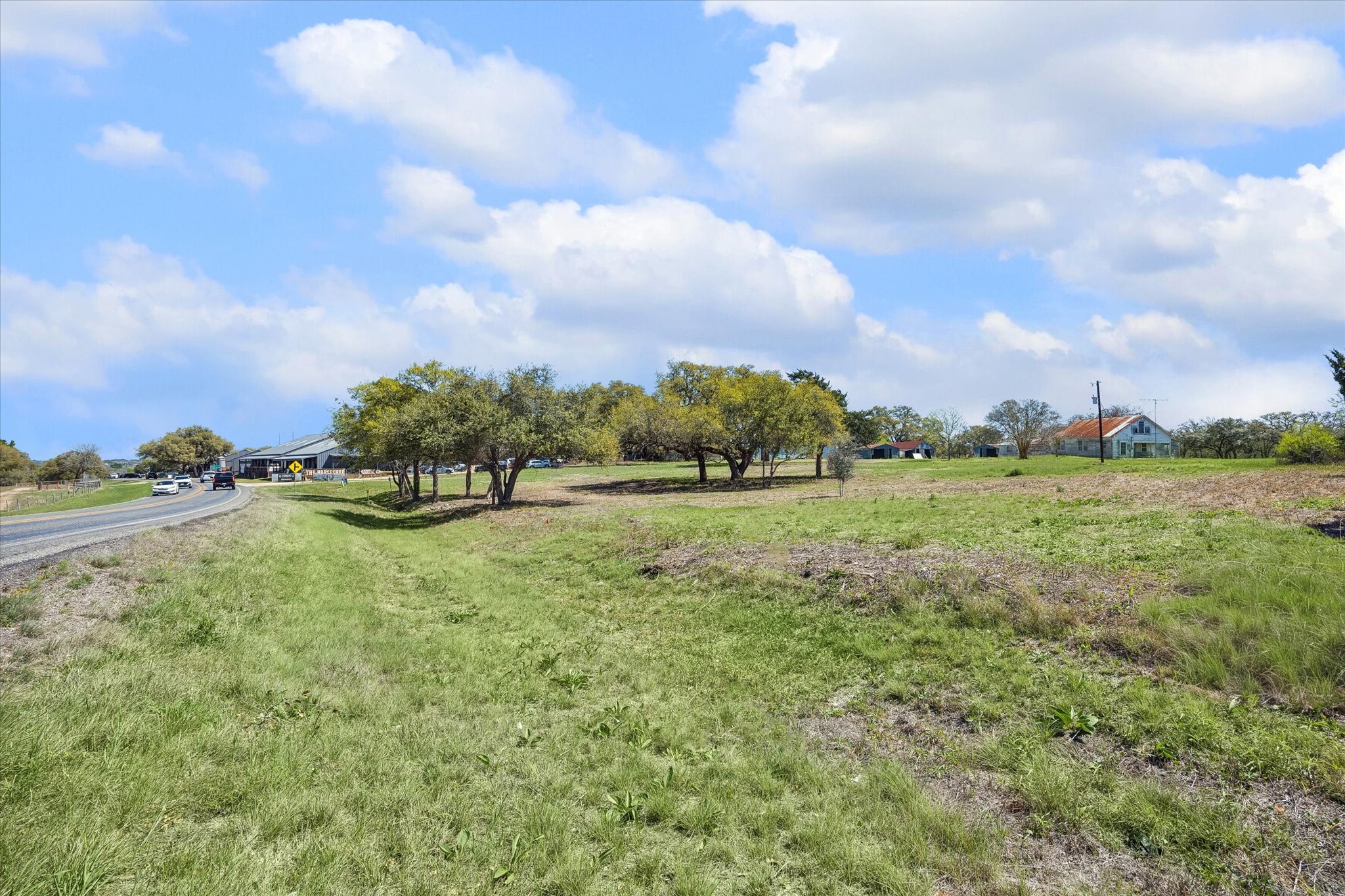 a view of a green field with wooden fence