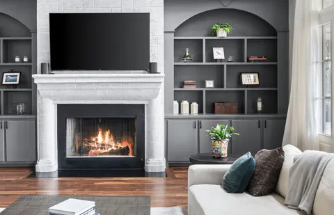 a living room with furniture a flat screen tv and a fireplace