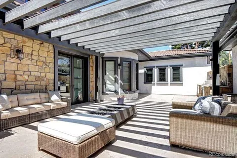 a view of a patio with a dining table and chairs with wooden floor and fence