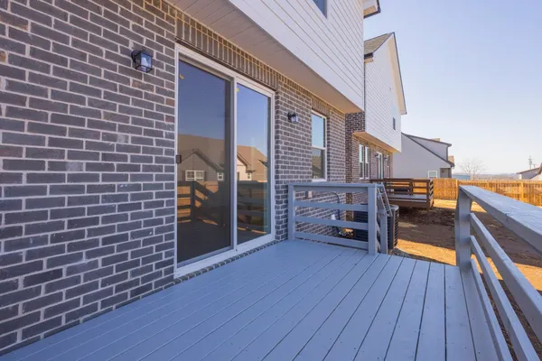 a view of a house with a barbeque and wooden stairs