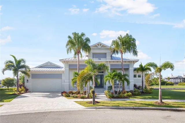 a view of a house with a yard and palm trees