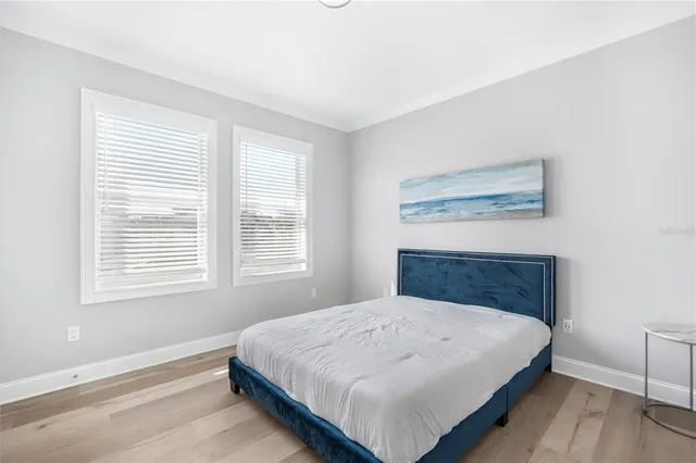 a bedroom with a bed a window and potted plant