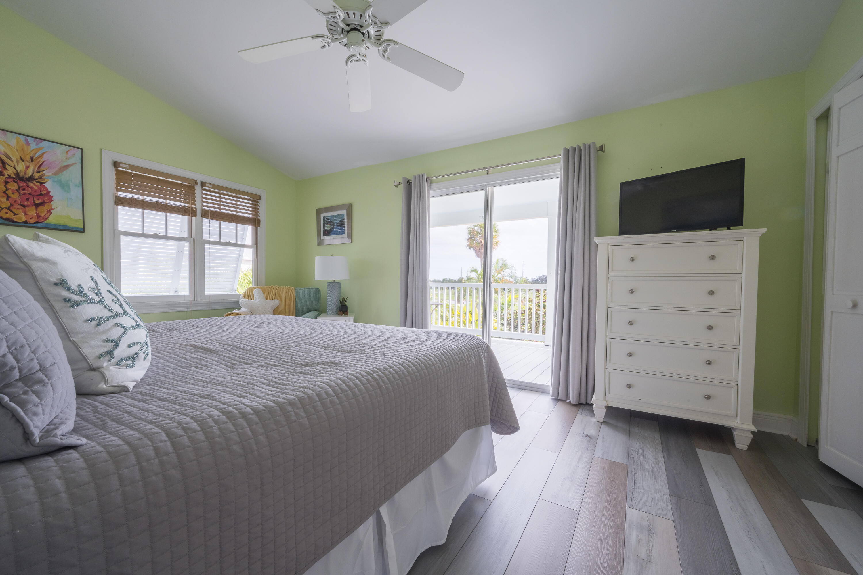 243 Golf Club Drive Key West, FL 33040 - Photo 23 of 54 a bedroom with a large bed and a flat tv screen on dresser