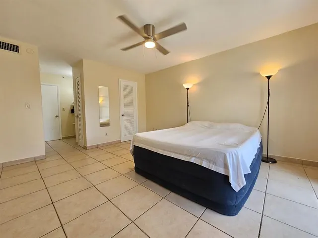 a bedroom with a bed and a ceiling fan