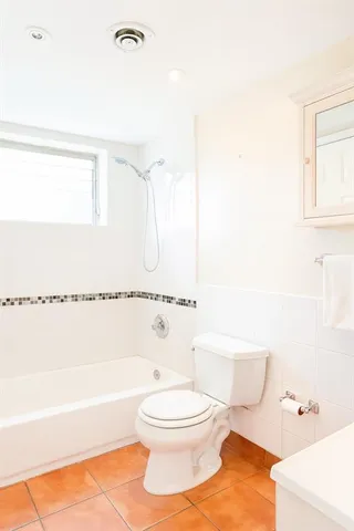 a bathroom with a toilet and a bath tub